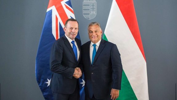 Tony Abbott shakes hands with Viktor Orban in front of Australian and Hungarian flags
