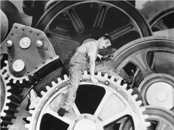 Screenshot from Charlie Chaplin's modern times of worker on cogs